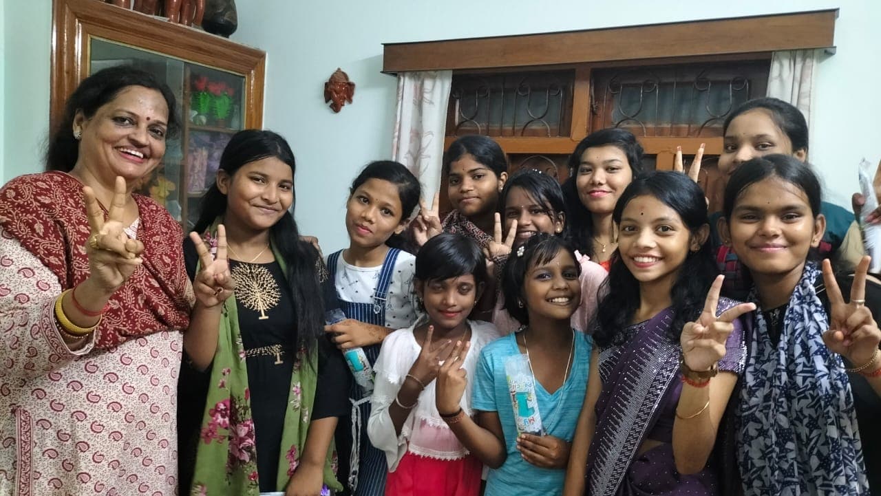 Women and girls smiling together at a community programme
